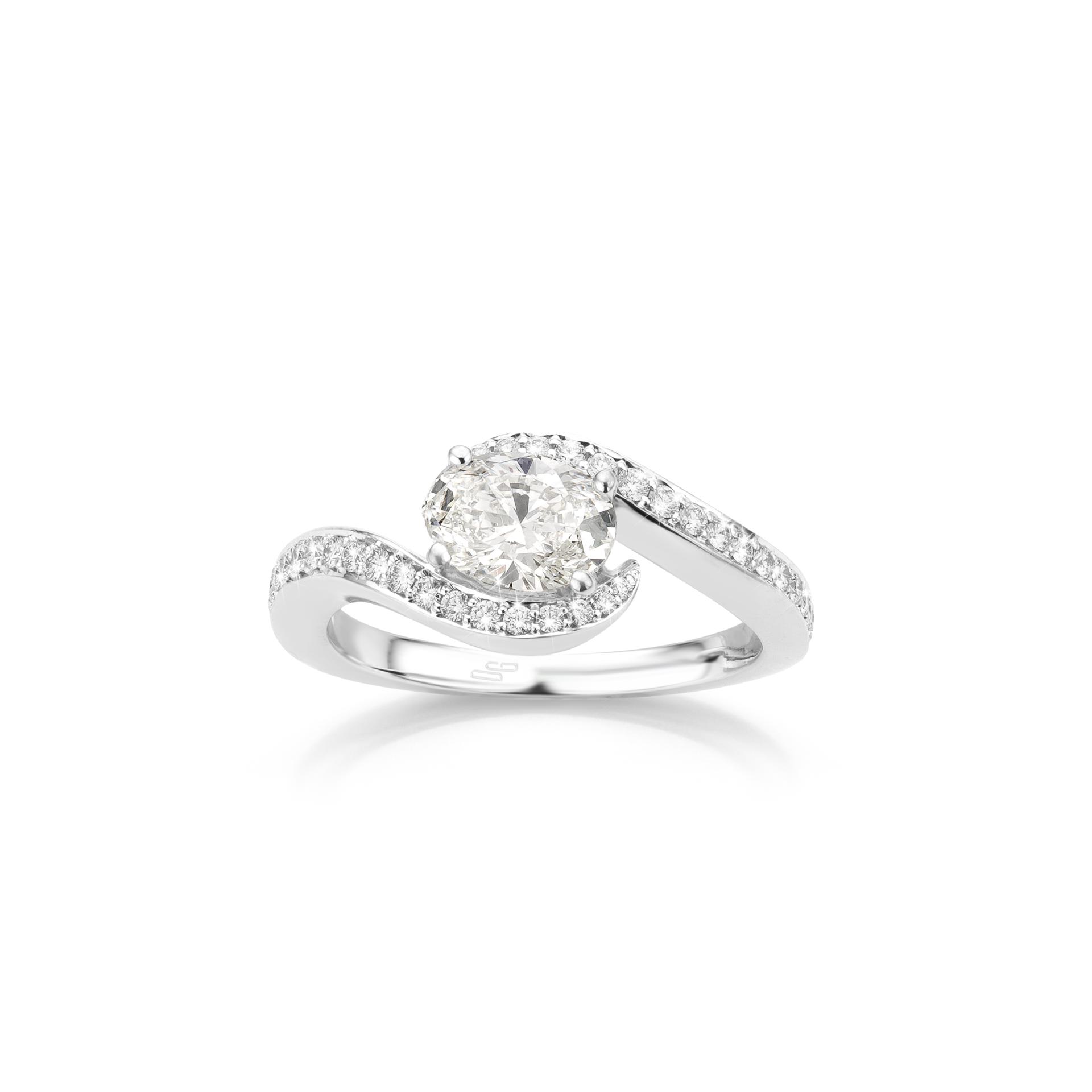 White gold ring set with oval shaped diamond and brilliant cut diamonds made by Maison De Greef