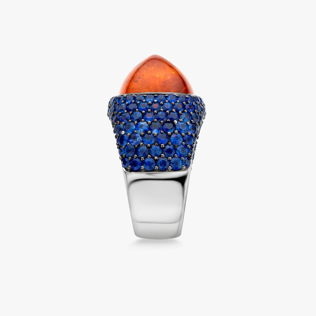 Solis ring in white gold set with a mandarin garnet and blue sapphires made by Maison De Greef